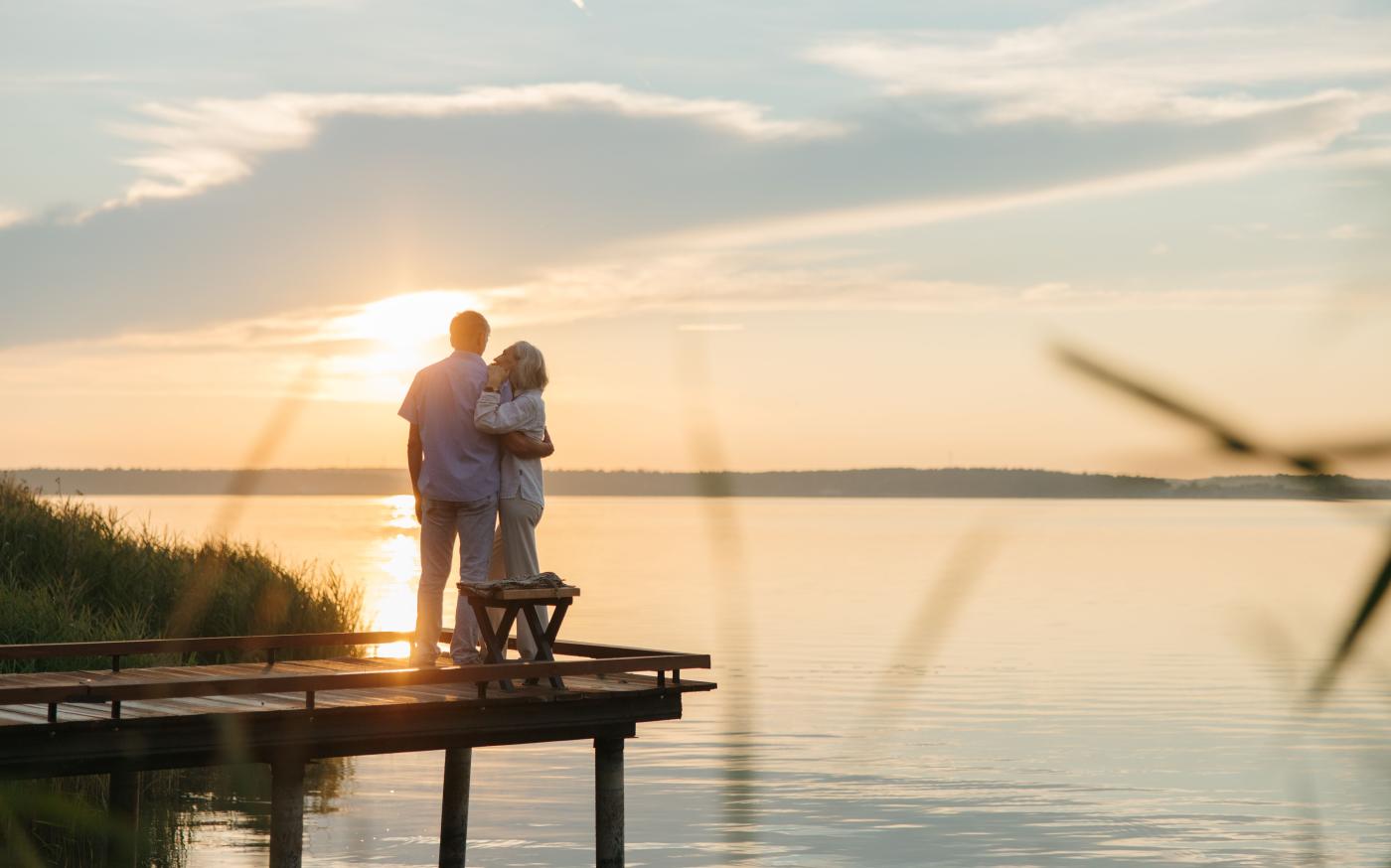 retired couple watching the sunset over the water