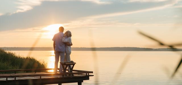 retired couple watching the sunset over the water